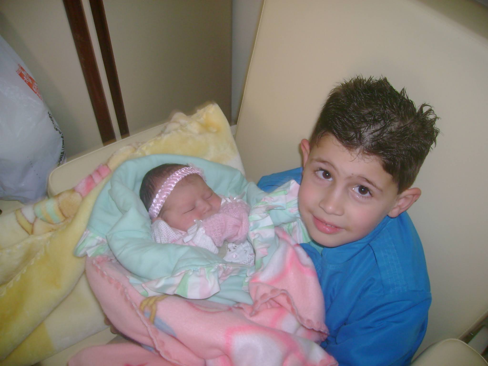 Photo of me holding my newborn sister Emanuela on my lap