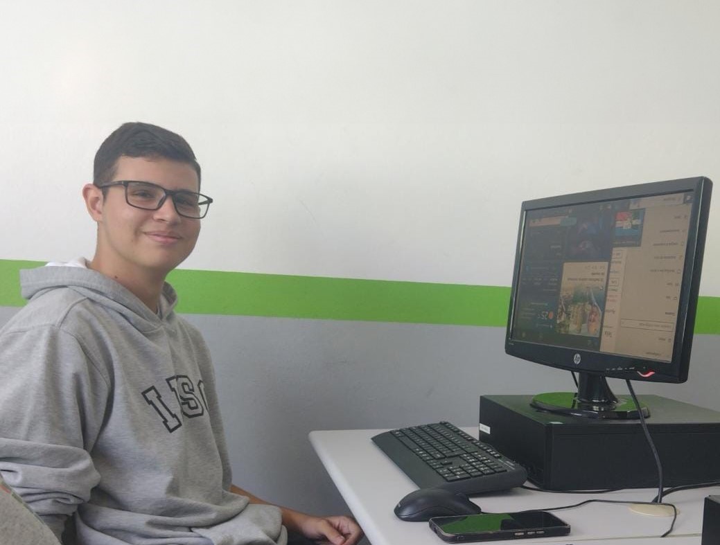 Photo of me sitting in front of a computer at IFSC Campus Araranguá